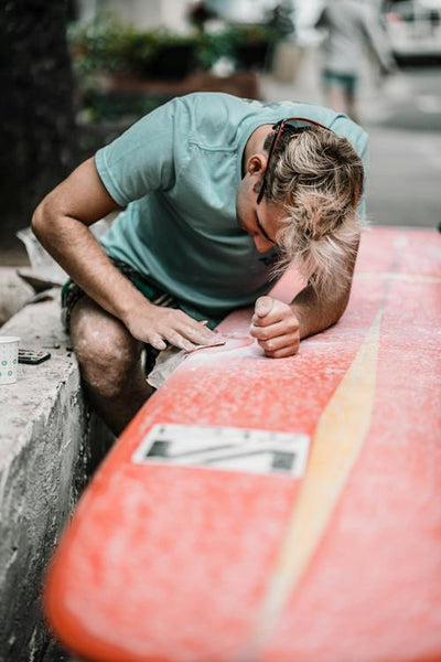 Man taking care of his surfboards