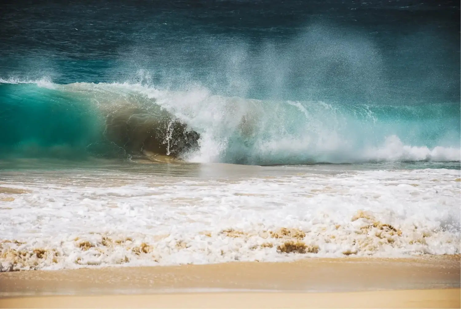 A large wave crashing against the shore at Puerto Escondido, Mexico. Puerto Escondido is known for its powerful waves that attract big wave surfers from around the world.