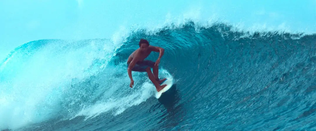 A surfer riding a wave at Teahupoo, Tahiti. This is one of the most famous big wave surf spots in the world.